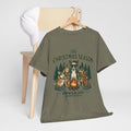 The Christmas Season Unisex T-Shirt — dogs settle in around a crackling campfire